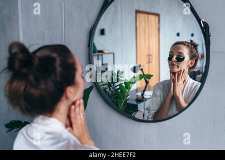 La jeune femme prend soin de sa peau faciale Banque D'Images