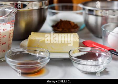 Ingrédients disposés avant la cuisson.Les ingrédients comprennent : l'œuf, le lait, le cacao, le beurre et la poudre à pâte. Banque D'Images