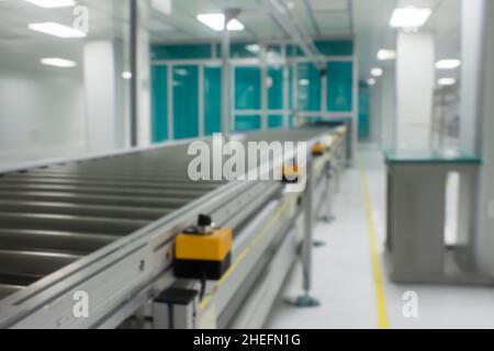 Convoyeur à rouleaux spécial dans la salle blanche. Image floue Banque D'Images