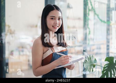 Portrait de la femme le propriétaire du café Barista sourit pendant que le café est ouvert.PME entrepreneur vendeur concept d'affaires. Banque D'Images