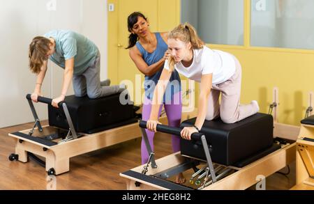 Adolescents d'entraînement pilates dans la salle de gym avec entraîneur Banque D'Images