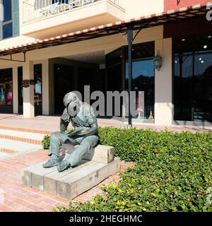 Sculpture en bronze d'un homme assis mangeant un sandwich et lisant un livre intitulé pour déjeuner, à la marina de Harbor Town à Hilton Head, en Caroline du Sud. Banque D'Images