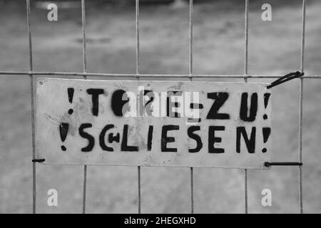 un signe avec le texte allemand à une porte qui signifie fermer la porte, mal orthographié a essayé de s'améliorer, mais sans succès. Banque D'Images