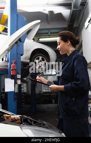 Vue latérale de l'écriture mécanique tatouée sur la planchette à pince près de la voiture en service Banque D'Images