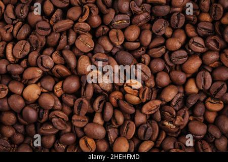 Fond fait de grains de café torréfiés avec des éclairs naturels. Banque D'Images