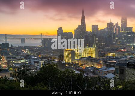 Lever de soleil brumeux au-dessus du centre-ville avec Bay Bridge en arrière-plan, San Francisco, Californie, États-Unis Banque D'Images