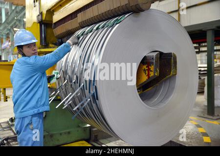 WUXI, CHINE - le 11 JANVIER 2022 - Un ouvrier emballe des produits de bandes en acier inoxydable lors d'un atelier à Wuxi, province de Jiangsu, Chine, le 11 janvier 2022.Le total Banque D'Images