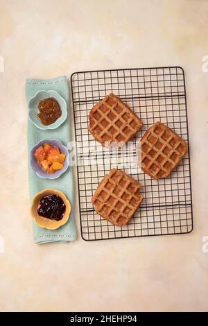 Vue de dessus de vegan, gaufres sans gluten avec confiture et garnitures de fruits prêtes à manger.Petit déjeuner ou dessert maison sain et savoureux. Banque D'Images