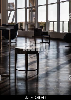 Bangkok, Thaïlande - 10 janvier 2022 : petite table en bois à l'intérieur dans la zone commune avec lumière du soleil du matin brille à travers les fenêtres dans la zone commune.Une lumière magnifique Banque D'Images