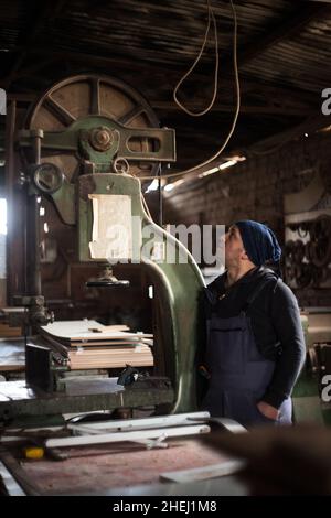 Portrait d'un jeune menuisier mâle, d'un jeune menuisier mâle debout dans son atelier de travail Banque D'Images