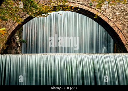 La vieille pierre, pont voûté, entre deux cascades à Palaiokaria, préfecture de Trikala, Thessalie, Grèce. Banque D'Images