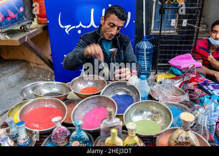 Un artiste du sable préparant des bouteilles de sable colorées, Aqaba, gouvernorat d'Aqaba, Jordanie. Banque D'Images