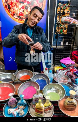 Un artiste du sable préparant des bouteilles de sable colorées, Aqaba, gouvernorat d'Aqaba, Jordanie. Banque D'Images