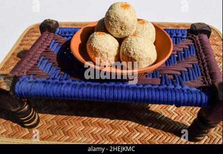 Recette de ladoo de til. Graines de sésame blanc enrobées de sucre jaggery.Des sucreries indiennes servies mangées du mithai traditionnel indien jusqu'au bati Banque D'Images