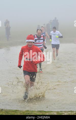 groupe de coureurs en train de traverser l'eau à la course de fond haverhill suffolk angleterre Banque D'Images