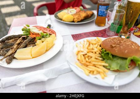 Délicieux hamburger de bœuf azoré et assiettes de poisson sur une table, île de Pico, Açores, Portugal Banque D'Images