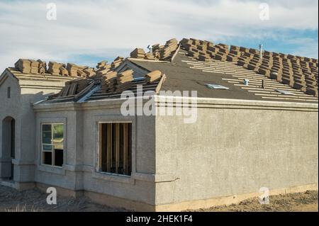 Nouvelle construction de maison avec tuiles de toit en premier plan Banque D'Images