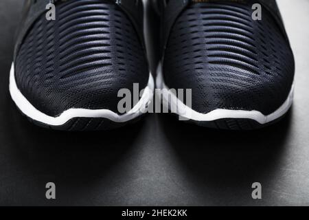 Chaussures de course à pied avec mesh et semelles noires et blanches en gros plan sur fond sombre.Vue de dessus des baskets de sport. Banque D'Images