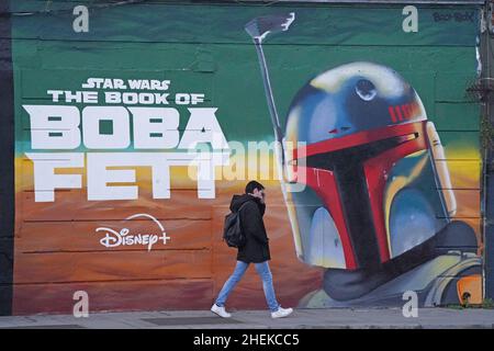 Une personne passe devant une fresque dans le centre-ville de Dublin, faisant la publicité de la série télévisée The Book of Boba Fett, qui fait partie de la franchise Star Wars.Date de la photo: Mardi 11 janvier 2022. Banque D'Images