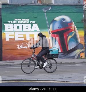 Une personne passe devant une fresque dans le centre-ville de Dublin, annonçant la série télévisée The Book of Boba Fett, qui fait partie de la franchise Star Wars.Date de la photo: Mardi 11 janvier 2022. Banque D'Images