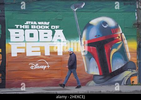 Une personne passe devant une fresque dans le centre-ville de Dublin, faisant la publicité de la série télévisée The Book of Boba Fett, qui fait partie de la franchise Star Wars.Date de la photo: Mardi 11 janvier 2022. Banque D'Images