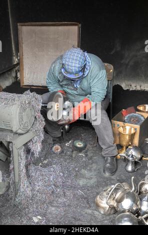 Ushaiqer, Arabie Saoudite, 1st janvier 2022: Homme travaillant dans un atelier poussiéreux, faisant des pots de café arabes Banque D'Images