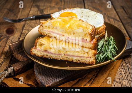 Croque monsieur et croque madame avec tranches de jambon, fromage emmental fondu et œufs, toasts français.Arrière-plan en bois.Vue de dessus Banque D'Images