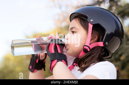 Gros plan de la petite fille dans l'eau potable des équipements sportifs.Activités de plein air. Banque D'Images