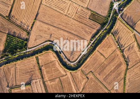 Vue aérienne des champs agricoles arides avec canal d'irrigation dans les terres agricoles à la campagne Banque D'Images