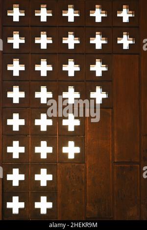 Fragment de la porte de l'Église catholique.Porte en métal avec trous en forme de croix. Banque D'Images