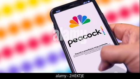 New York, Etats-Unis, septembre 2021 : main tenant un téléphone avec l'application mobile Peacock TV sur l'écran avec un arrière-plan flou.Vidéo américaine Banque D'Images