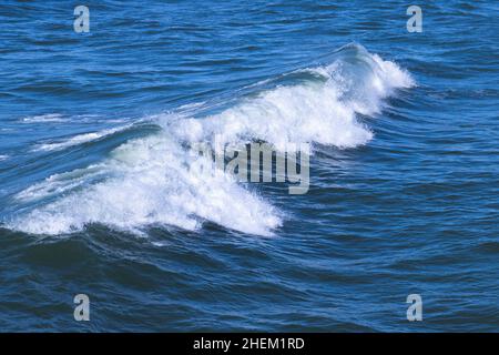 Vague avec mousse blanche va au-dessus de l'eau de mer bleu profond, photo de fond naturel Banque D'Images