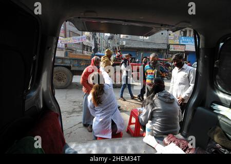 Non exclusif : NEW DELHI, INDE - 11 JANVIER 2022 : les agents de santé effectuent des tests rapides par écouvillonnage auprès des vendeurs locaux pour détecter la maladie de Covid-19 dans le New Delh local Banque D'Images