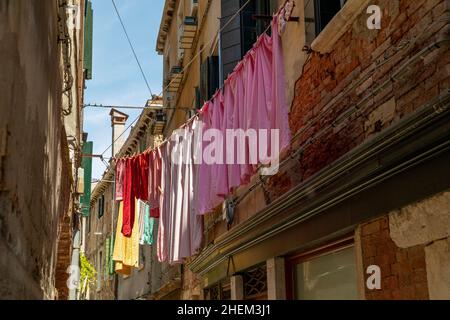 Route étroite à Venise avec des lignes de vêtements entre les anciennes maisons vénitiennes, Italie Banque D'Images