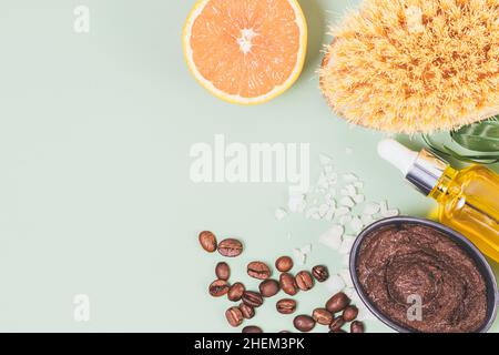 Gommage au café naturel anticellulite avec de l'huile essentielle d'orange et du sel à côté de la brosse de massage, pose à plat avec espace de copie Banque D'Images