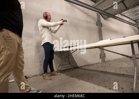 Austin Texas USA, octobre 2021 : Kyle Murphy, membre du Bitcoin Club et organisateur, tourne à The Range, un lieu de tournage en intérieur dans le sud d'Austin, pour un événement social le samedi où les membres ont tiré des centaines de tours à des cibles.©Bob Daemmrich Banque D'Images