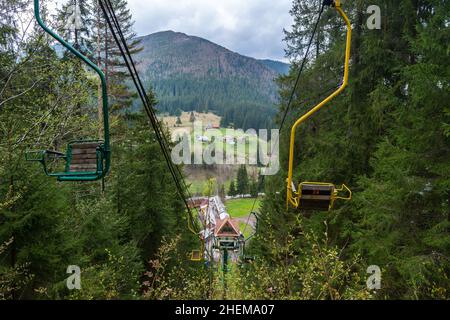 Ancienne remontée mécanique.Arbres et montagnes en arrière-plan.Skipass abandonné.Siège de levage jaune avec numéro 24. Banque D'Images