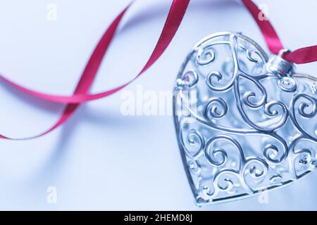 Carte de vœux Saint-Valentin, beau coeur argenté avec ruban sur fond blanc Banque D'Images