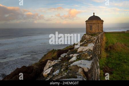 L'emblématique temple de Mussendun surplombe majestueusement l'océan au large de la côte nord d'Antrim. Banque D'Images