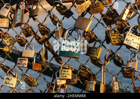 Cadenas aux noms de couples sur la déclaration de l'amour éternel, enfermé sur la clôture en maille de la poste des Arts à Paris, France. Banque D'Images