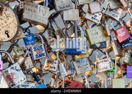 Cadenas aux noms de couples sur la déclaration de l'amour éternel, enfermé sur la clôture en maille de la poste des Arts à Paris, France. Banque D'Images