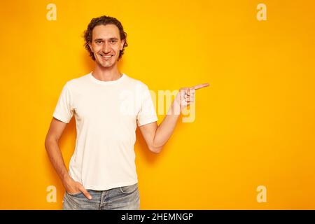 un touriste en vacances avec un smartphone entre ses mains écrit un message et sourit. isolé sur fond jaune. espace pour le texte. concept de personnes, loisirs, communication dans les réseaux sociaux.Photo de haute qualité Banque D'Images