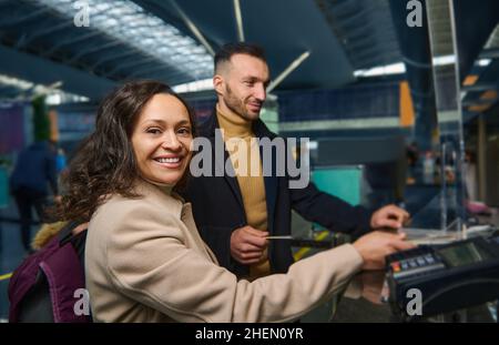Beau couple ethnique d'âge moyen - femme d'origine moyen-orientale et beau homme caucasien tenant des passeports tout en passant par le passeport an Banque D'Images