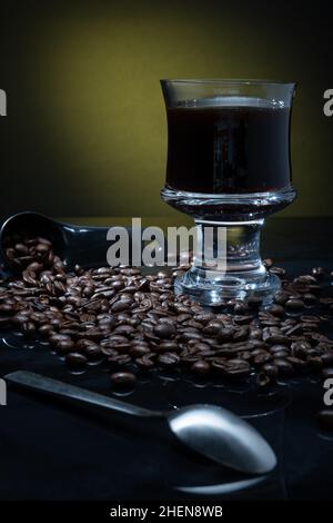 Helsinki / Finlande - 11 JANVIER 2022 : une tasse de café frais entourée de grains de café sur fond sombre. Banque D'Images