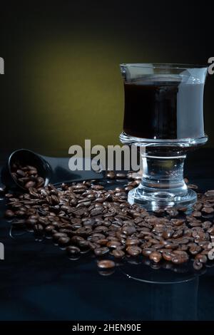 Helsinki / Finlande - 11 JANVIER 2022 : une tasse de café frais entourée de grains de café sur fond sombre. Banque D'Images