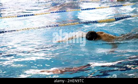 Homme natation dans la piscine.Mettre en forme les jeunes hommes entraînement de nageur dans la piscine.Jeune homme nageant sur la plage dans une piscine.Jeune athlète freestyle Banque D'Images