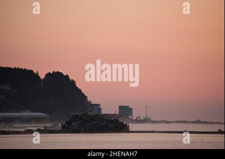 L'aube et un océan brumeux mettent en évidence les dommages causés par le tsunami à Minamisanrikucho quelques mois après le tsunami de 2011. Banque D'Images