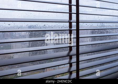 Stores métalliques sur les fenêtres par temps pluvieux Banque D'Images