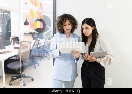 Des femmes d'affaires heureuses qui discutent et font du brainstorming ensemble au bureau. Banque D'Images