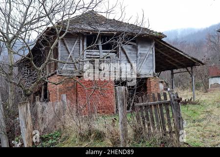Ancienne grange aux briques rouges et mur en bois à la campagne, le matin froid de l'hiver Banque D'Images